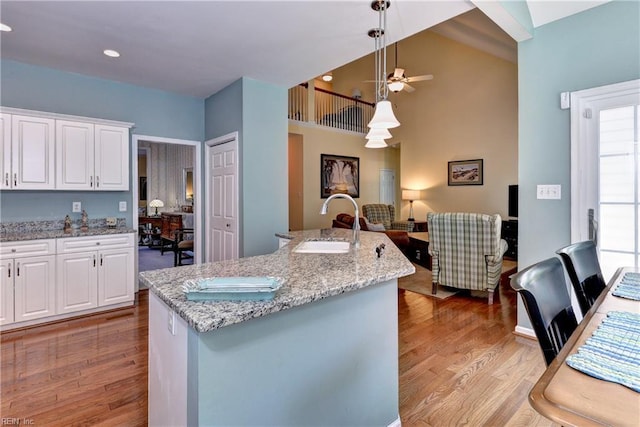 2712 Holly Ridge Ln, Williamsburg, VA 23185 - kitchen featuring ceiling fan, wood finished floors, white cabinetry, decorative light fixtures, and light stone countertops