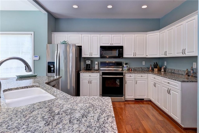 2712 Holly Ridge Ln, Williamsburg, VA 23185 - kitchen with stainless steel appliances, white cabinets, wood finished floors, light stone countertops, and recessed lighting