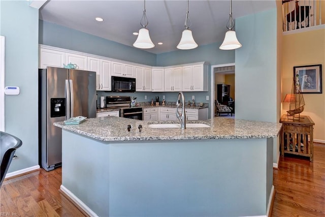 2712 Holly Ridge Ln, Williamsburg, VA 23185 - kitchen featuring stainless steel appliances, wood finished floors, white cabinetry, and recessed lighting
