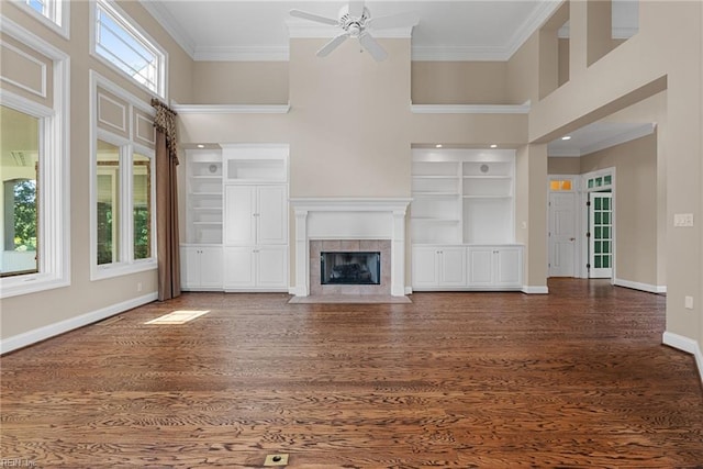 308 Rivers Edge, Williamsburg, VA 23185 - unfurnished living room featuring ornamental molding, ceiling fan, wood finished floors, a towering ceiling, and a tiled fireplace