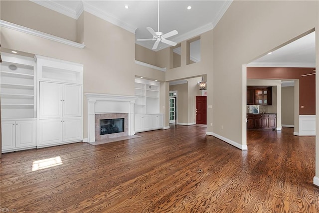 308 Rivers Edge, Williamsburg, VA 23185 - unfurnished living room featuring built in shelves, wood finished floors, a ceiling fan, a high ceiling, and a premium fireplace