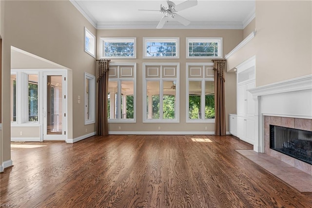 308 Rivers Edge, Williamsburg, VA 23185 - unfurnished living room featuring a ceiling fan, a tile fireplace, wood finished floors, a towering ceiling, and ornamental molding