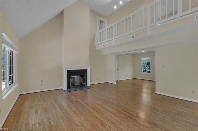 4505 Wimbledon Way, Williamsburg, VA 23188 - unfurnished living room featuring high vaulted ceiling, wood finished floors, and a glass covered fireplace