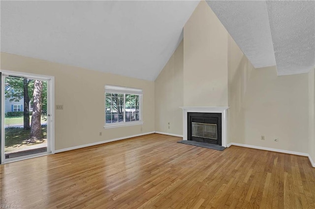 4505 Wimbledon Way, Williamsburg, VA 23188 - unfurnished living room featuring light wood-style flooring, a glass covered fireplace, lofted ceiling, and a textured ceiling