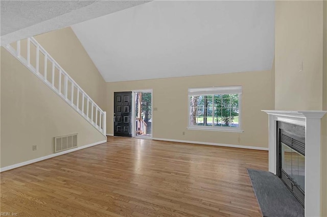 4505 Wimbledon Way, Williamsburg, VA 23188 - unfurnished living room featuring a fireplace, stairs, wood finished floors, and high vaulted ceiling