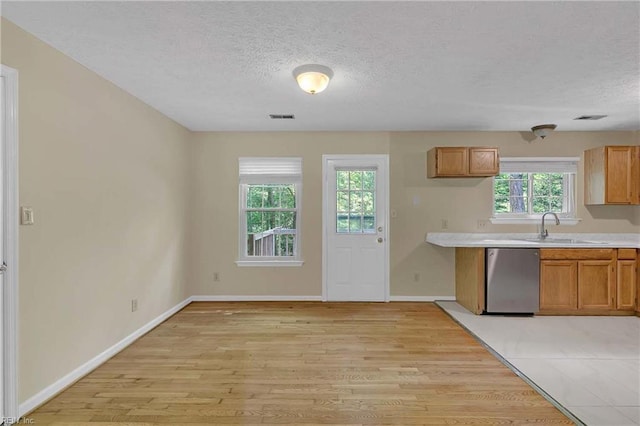 4505 Wimbledon Way, Williamsburg, VA 23188 - kitchen with dishwasher, a textured ceiling, light wood-style flooring, light countertops, and brown cabinets