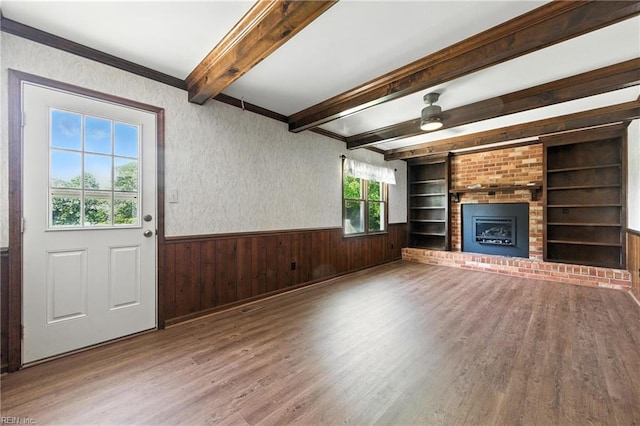 60 Dillwyn Dr, Newport News, VA 23602 - unfurnished living room with a wainscoted wall, wood finished floors, a ceiling fan, beam ceiling, and a brick fireplace