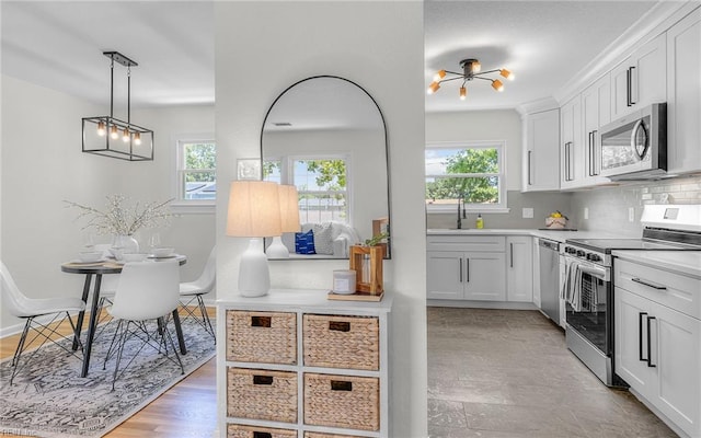 3048 John Hancock Dr, Virginia Beach, VA 23452 - kitchen with stainless steel appliances, healthy amount of natural light, white cabinetry, and light countertops