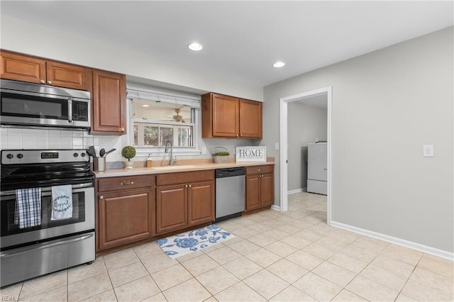 600 Whitechapel Dr, Virginia Beach, VA 23455 - kitchen featuring appliances with stainless steel finishes, washer / clothes dryer, light countertops, recessed lighting, and brown cabinets