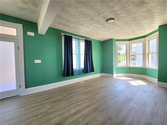 110 S Willard Ave, Hampton, VA 23663 - spare room with wood finished floors, healthy amount of natural light, beam ceiling, and a textured ceiling