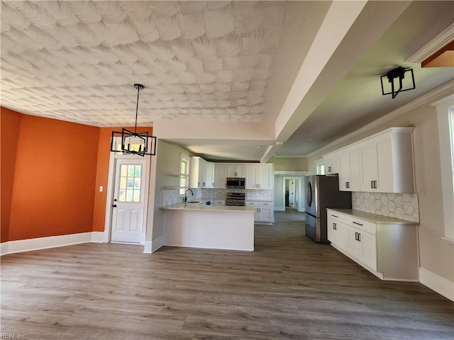 110 S Willard Ave, Hampton, VA 23663 - kitchen featuring appliances with stainless steel finishes, decorative backsplash, white cabinetry, a peninsula, and light countertops