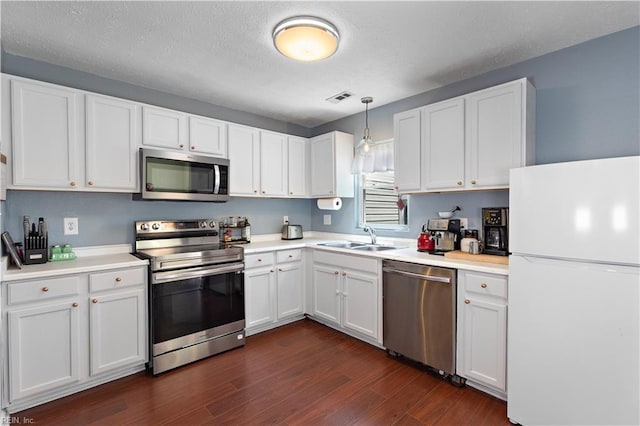 3009 Aaron Dr, Chesapeake, VA 23323 - kitchen with stainless steel appliances, dark wood-style floors, white cabinetry, and a textured ceiling