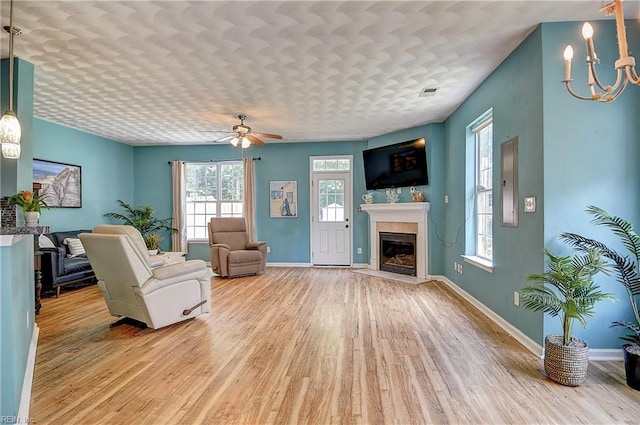 1212 Gunn Hall Dr, Virginia Beach, VA 23454 - living room with light wood-style flooring, plenty of natural light, a fireplace, and a chandelier
