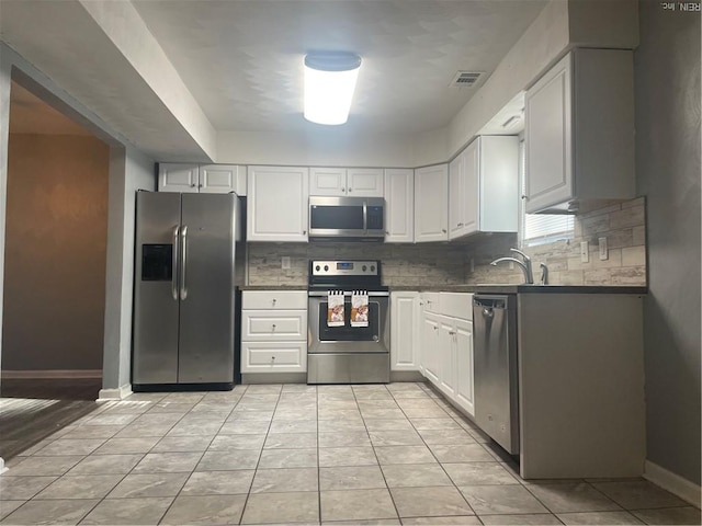 1122 Old Clubhouse Rd, Virginia Beach, VA 23453 - kitchen featuring stainless steel appliances, backsplash, dark countertops, and white cabinetry