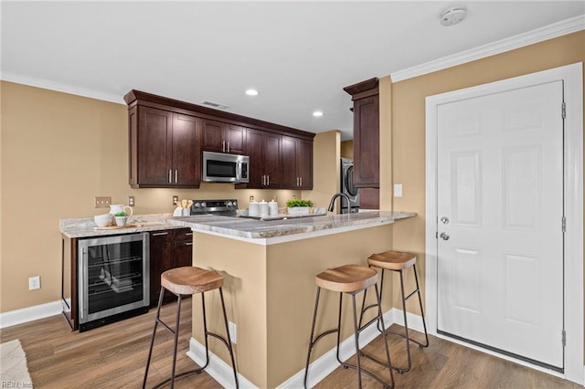 5001 Heathglen Cir, Virginia Beach, VA 23456 - kitchen with beverage cooler, stainless steel microwave, wood finished floors, a kitchen bar, and crown molding
