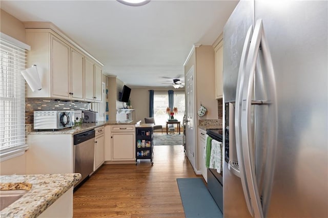 503 Carters Grove Ct, Hampton, VA 23663 - kitchen featuring stainless steel appliances, a peninsula, cream cabinets, and light wood-style floors