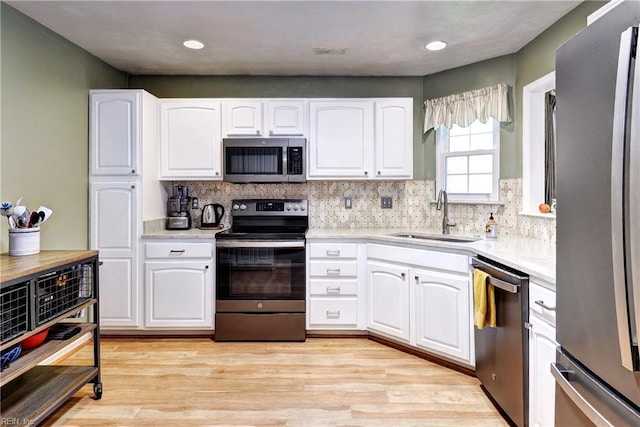 601 Commons Way, Williamsburg, VA 23185 - kitchen with appliances with stainless steel finishes, white cabinetry, light countertops, decorative backsplash, and recessed lighting