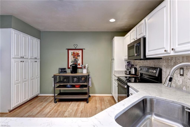 601 Commons Way, Williamsburg, VA 23185 - kitchen with stainless steel microwave, black electric range oven, light stone countertops, white cabinetry, and light wood-style flooring