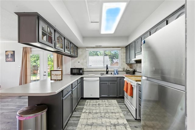 3725 Kingsmill Walk, Virginia Beach, VA 23452 - kitchen with white appliances, a peninsula, light wood-style flooring, glass insert cabinets, and light countertops