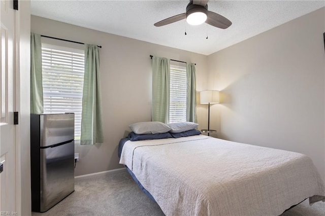 1504 River Creek Cres, Suffolk, VA 23434 - carpeted bedroom featuring freestanding refrigerator, multiple windows, ceiling fan, and a textured ceiling