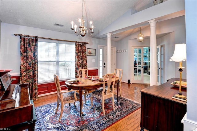 3284 Reades Way, Williamsburg, VA 23185 - dining room featuring ornate columns, wood finished floors, a chandelier, lofted ceiling, and a wainscoted wall