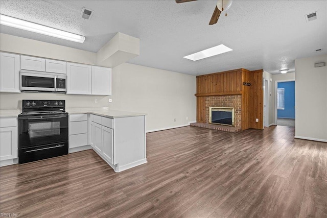 1150 Ocean Pebbles Way, Virginia Beach, VA 23451 - kitchen featuring electric range, stainless steel microwave, open floor plan, a textured ceiling, and a peninsula