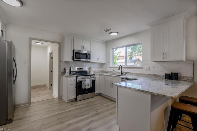 552 Boxwood Ln, Virginia Beach, VA 23452 - kitchen featuring stainless steel appliances, a peninsula, decorative backsplash, and white cabinetry