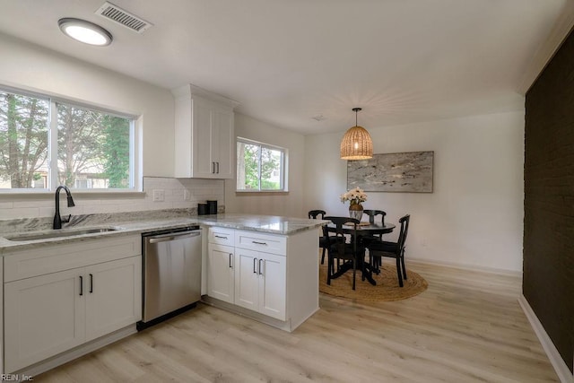 552 Boxwood Ln, Virginia Beach, VA 23452 - kitchen with stainless steel dishwasher, light wood-type flooring, white cabinets, backsplash, and light stone counters