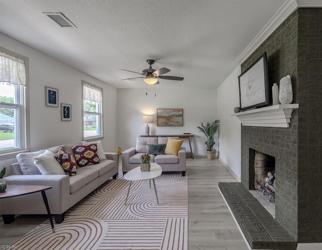 552 Boxwood Ln, Virginia Beach, VA 23452 - living room with a brick fireplace, light wood-style flooring, ceiling fan, and a textured ceiling