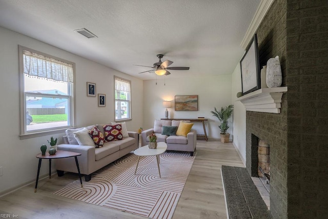 552 Boxwood Ln, Virginia Beach, VA 23452 - living room featuring light wood-type flooring, a fireplace, ceiling fan, and a textured ceiling
