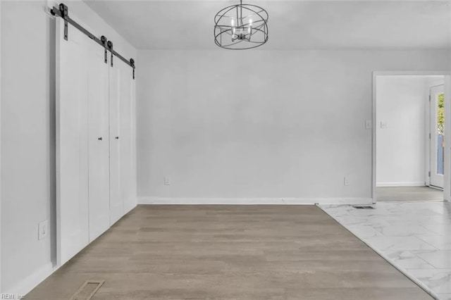 11 Alpine St, Newport News, VA 23606 - unfurnished dining area with a barn door, a chandelier, and wood finished floors