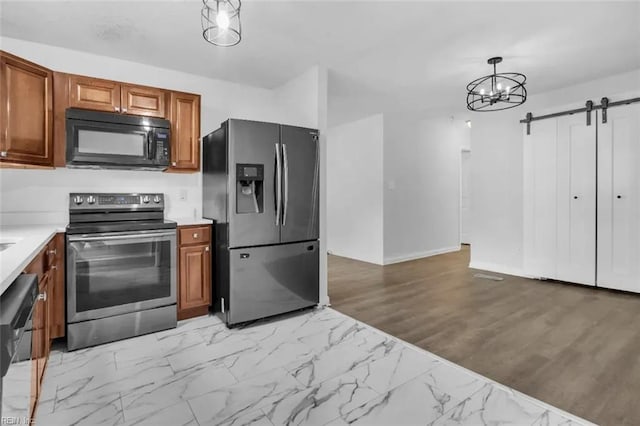 11 Alpine St, Newport News, VA 23606 - kitchen with stainless steel appliances, a barn door, light countertops, brown cabinetry, and hanging light fixtures