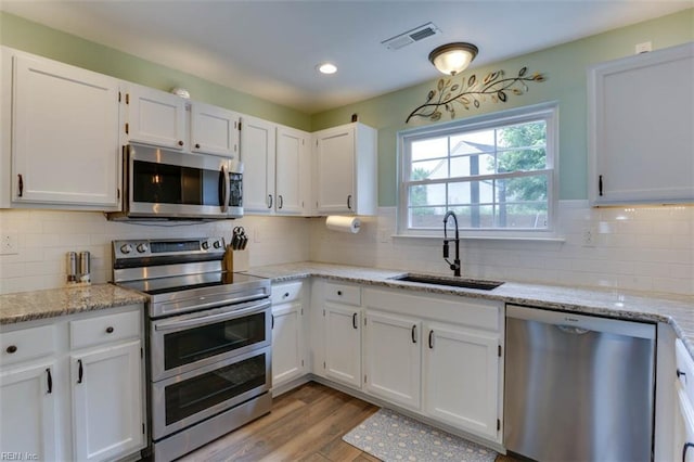 408 Lodge Cv, Chesapeake, VA 23323 - kitchen with appliances with stainless steel finishes, white cabinets, light wood finished floors, and recessed lighting