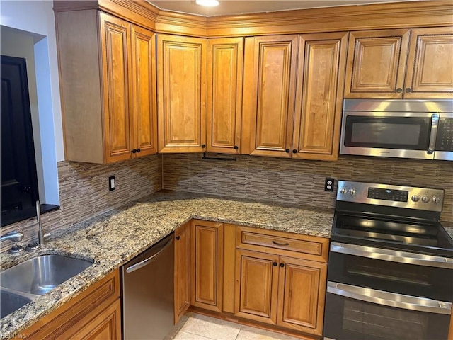 1122 Gatling Dr, Hampton, VA 23666 - kitchen with stainless steel appliances, tasteful backsplash, and brown cabinets