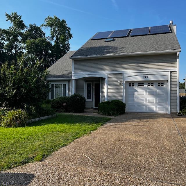 719 Kensington Dr, Newport News, VA 23602 - view of front of house featuring roof mounted solar panels, driveway, a front yard, a shingled roof, and a garage
