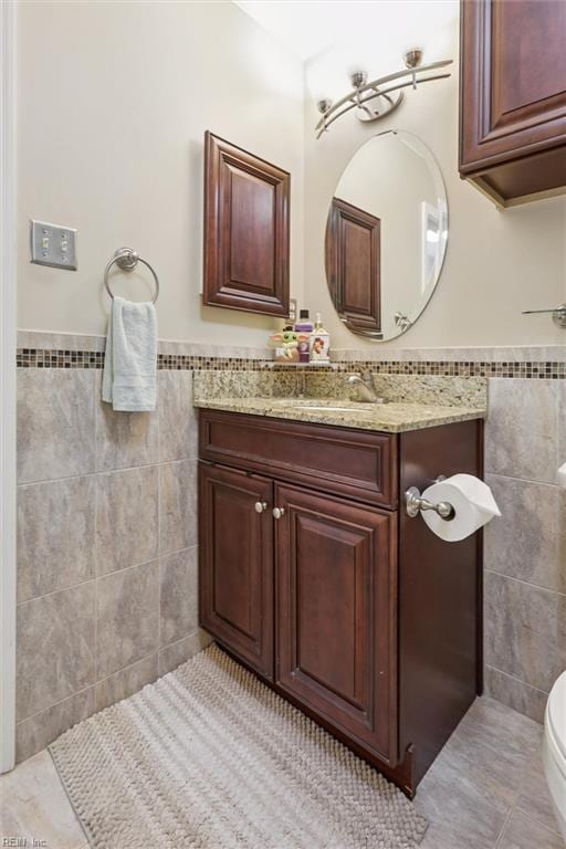 719 Kensington Dr, Newport News, VA 23602 - bathroom featuring tile walls, vanity, wainscoting, and tile patterned flooring