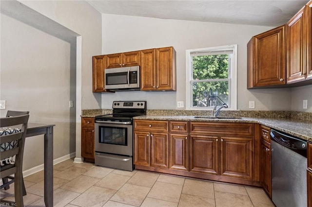 149 Ransone St, Hampton, VA 23669 - kitchen featuring stainless steel appliances, vaulted ceiling, brown cabinets, dark stone countertops, and light tile patterned flooring