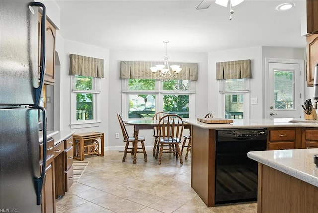 3805 Fleet Ct, Portsmouth, VA 23703 - kitchen with black appliances, a chandelier, hanging light fixtures, light tile patterned floors, and brown cabinets
