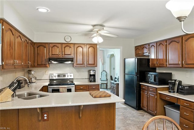 3805 Fleet Ct, Portsmouth, VA 23703 - kitchen with black appliances, under cabinet range hood, a ceiling fan, a peninsula, and a breakfast bar