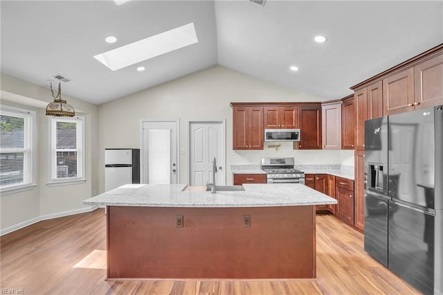 2416 Broadnax Cir, Chesapeake, VA 23323 - kitchen featuring stainless steel appliances, a skylight, vaulted ceiling, light wood-style flooring, and an island with sink