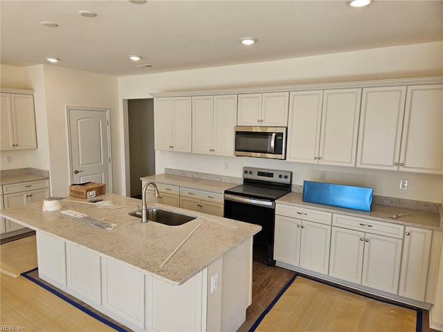 208 St Pauls Ave Unit 30-3, Smithfield, VA 23430 - kitchen featuring stainless steel microwave, range with electric stovetop, light wood-style flooring, recessed lighting, and a center island with sink