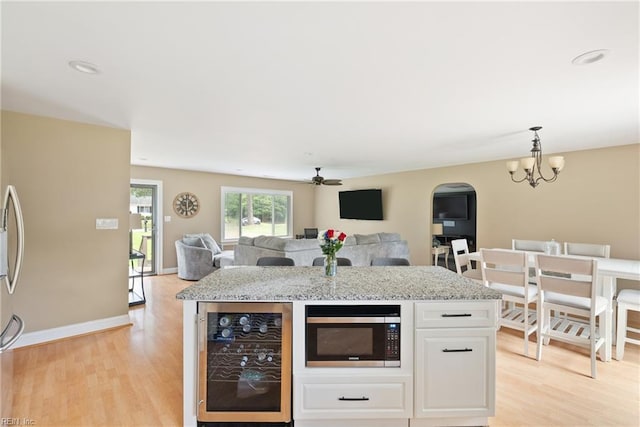 6019 Tabiatha Ln, Lanexa, VA 23089 - kitchen featuring beverage cooler, stainless steel microwave, arched walkways, and light wood-style flooring