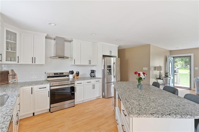 6019 Tabiatha Ln, Lanexa, VA 23089 - kitchen featuring stainless steel appliances, wall chimney range hood, a center island, backsplash, and white cabinets
