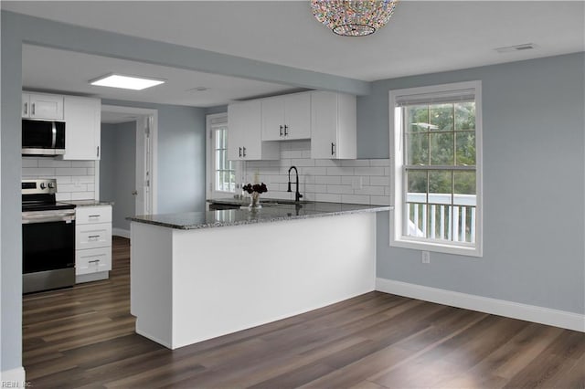 126 Ridge Rd, Poquoson, VA 23662 - kitchen with appliances with stainless steel finishes, backsplash, stone counters, white cabinets, and dark wood-style floors