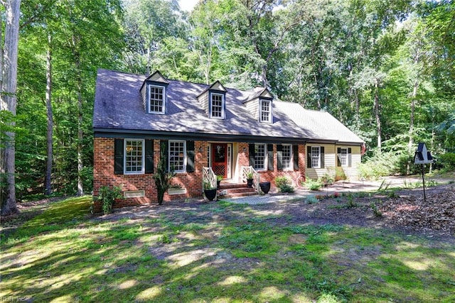 102 Whitehall Ct, Williamsburg, VA 23188 - cape cod home featuring brick siding, covered porch, and a front yard