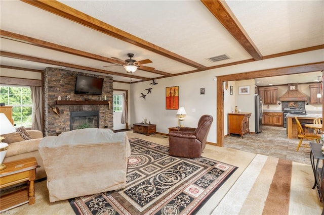 2501 Clancie Rd, Shacklefords, VA 23156 - living room featuring a fireplace, beam ceiling, ceiling fan, and light tile patterned floors