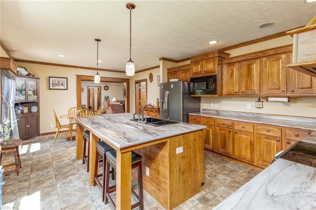 2501 Clancie Rd, Shacklefords, VA 23156 - kitchen with stainless steel refrigerator with ice dispenser, black microwave, brown cabinets, light stone countertops, and ornamental molding