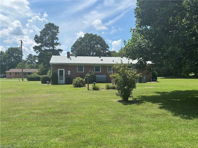 906 Rebecca St, Franklin, VA 23851 - rear view of house with a lawn and brick siding