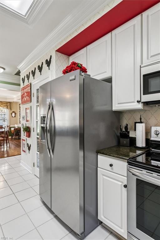 3139 Cider House Rd, Toano, VA 23168 - kitchen with stainless steel appliances, ornamental molding, white cabinetry, light tile patterned floors, and dark countertops