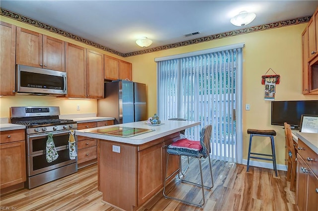 1132 Broadholme Pl Unit 642, Virginia Beach, VA 23455 - kitchen with appliances with stainless steel finishes, light wood-style flooring, light countertops, a center island, and brown cabinets